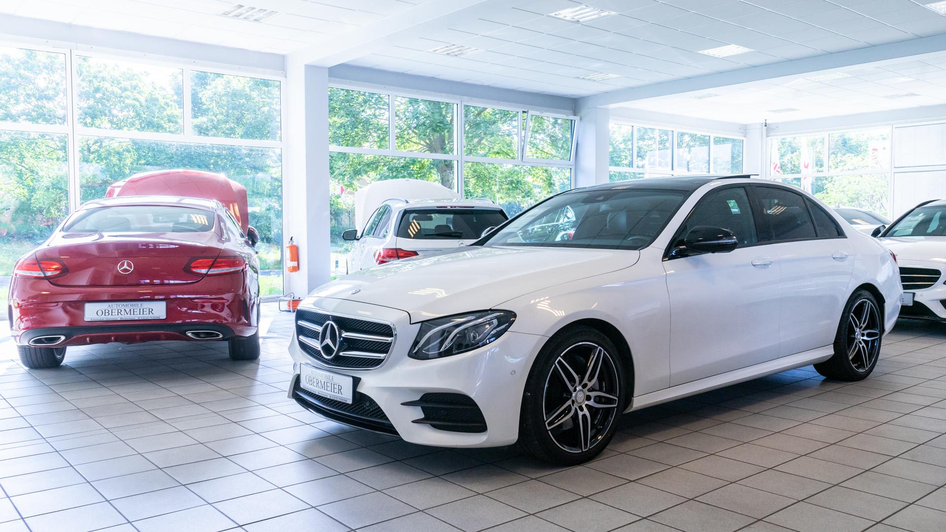 Rotes und weißes Fahrzeug von Mercedes Benz in Ausstellungshalle